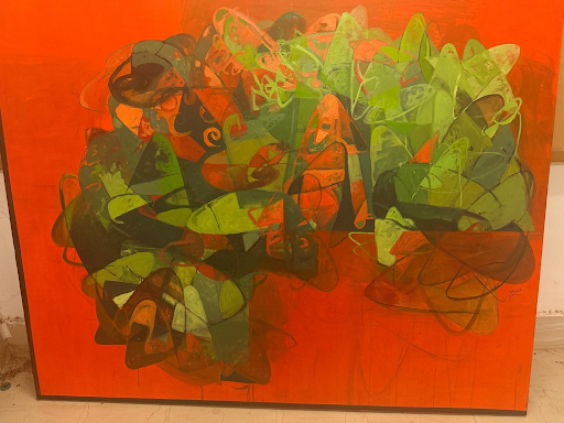 An abstract painting on an orange ground, with clustered green, black and orange looping and triangular shapes filling the centre.