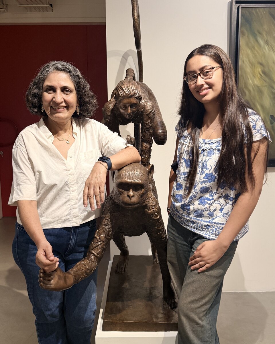 Seema Kohli, left, with interviewer Ariya Mukherjee-Gandhi beside a bronze sculpture in a gallery.